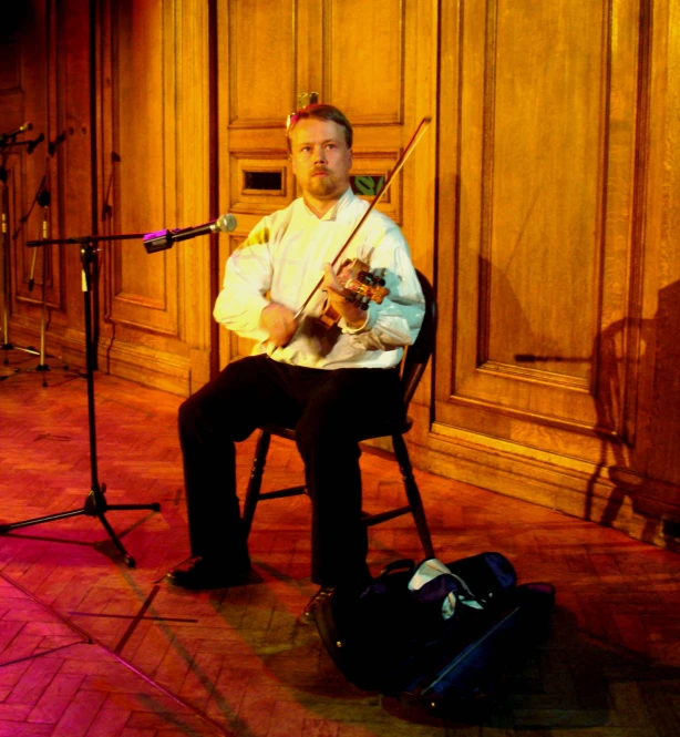 a man sits in front of a guitar in an auditorium