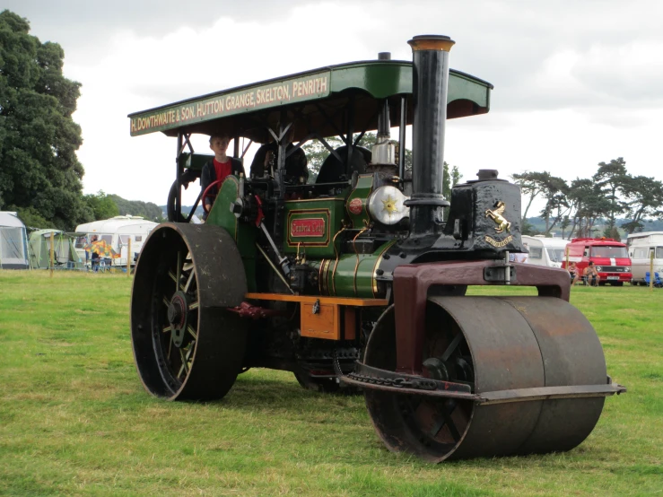 a vintage tractor at a festival with a man on the front