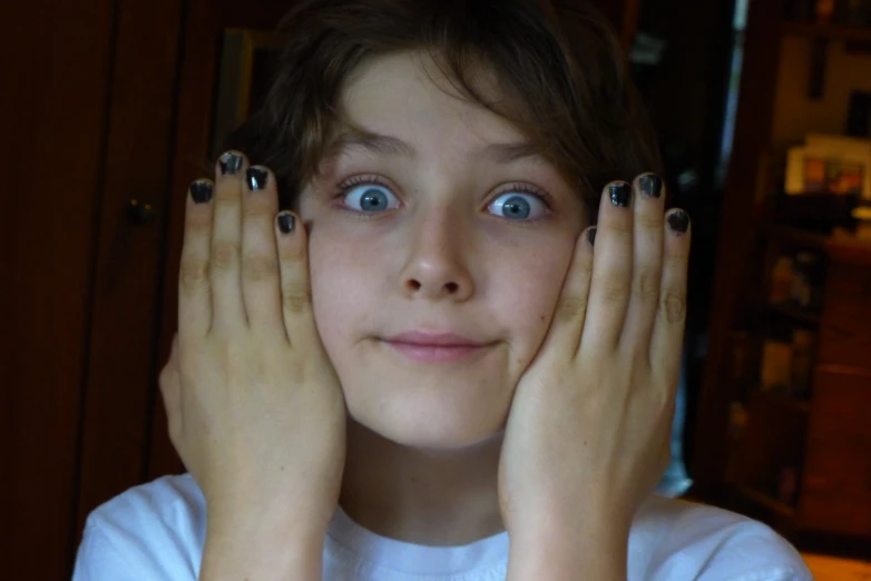 a person with blue eyes wearing silver nails
