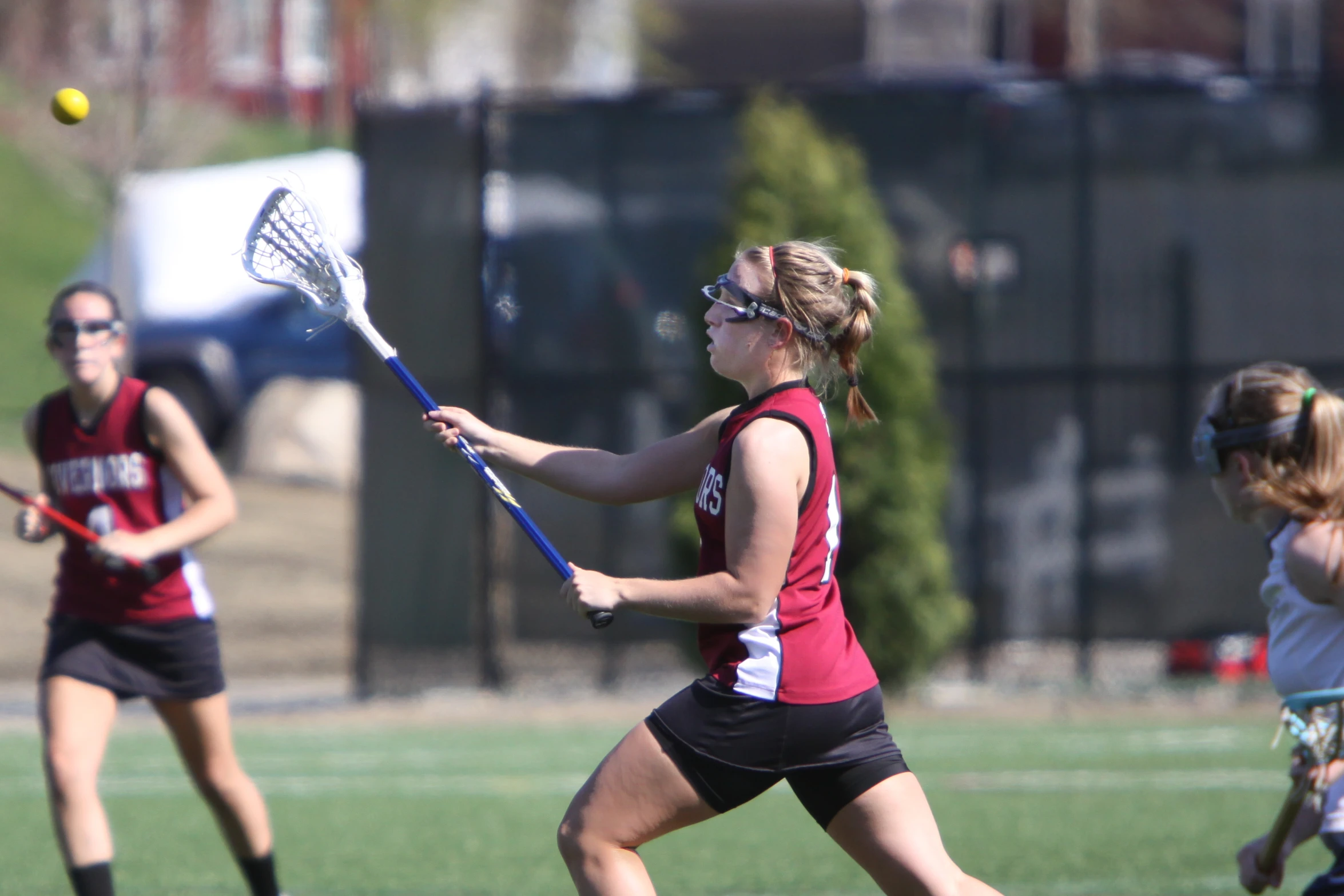 a female lacrosse player with a ball in her hands