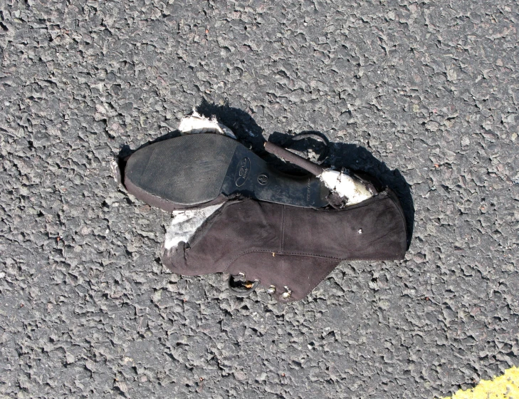 a pair of worn out shoes are laying on the sidewalk