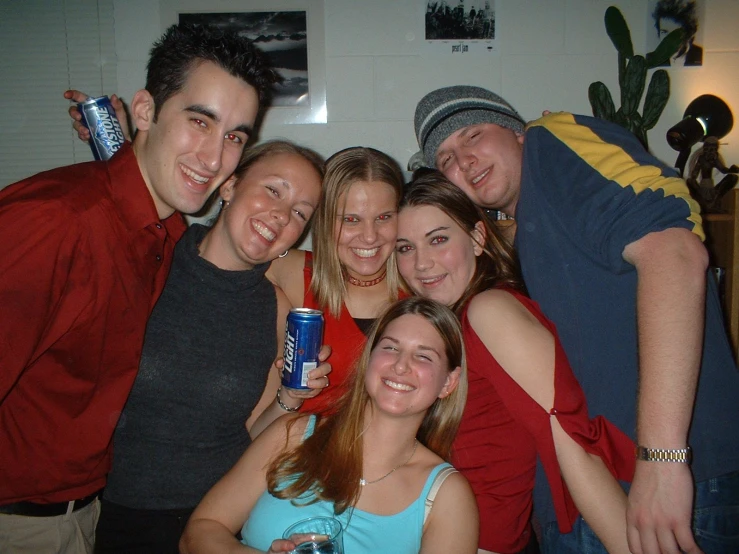 a group of young friends drinking beer and posing for the camera