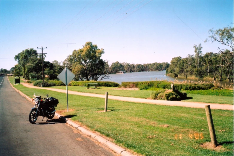 a motorcycle parked along a grassy road near the ocean