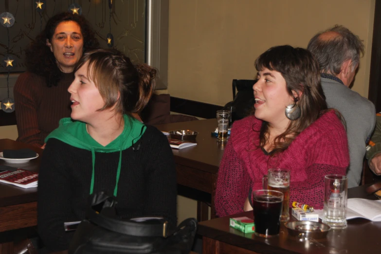 two women sit at the table as people look on