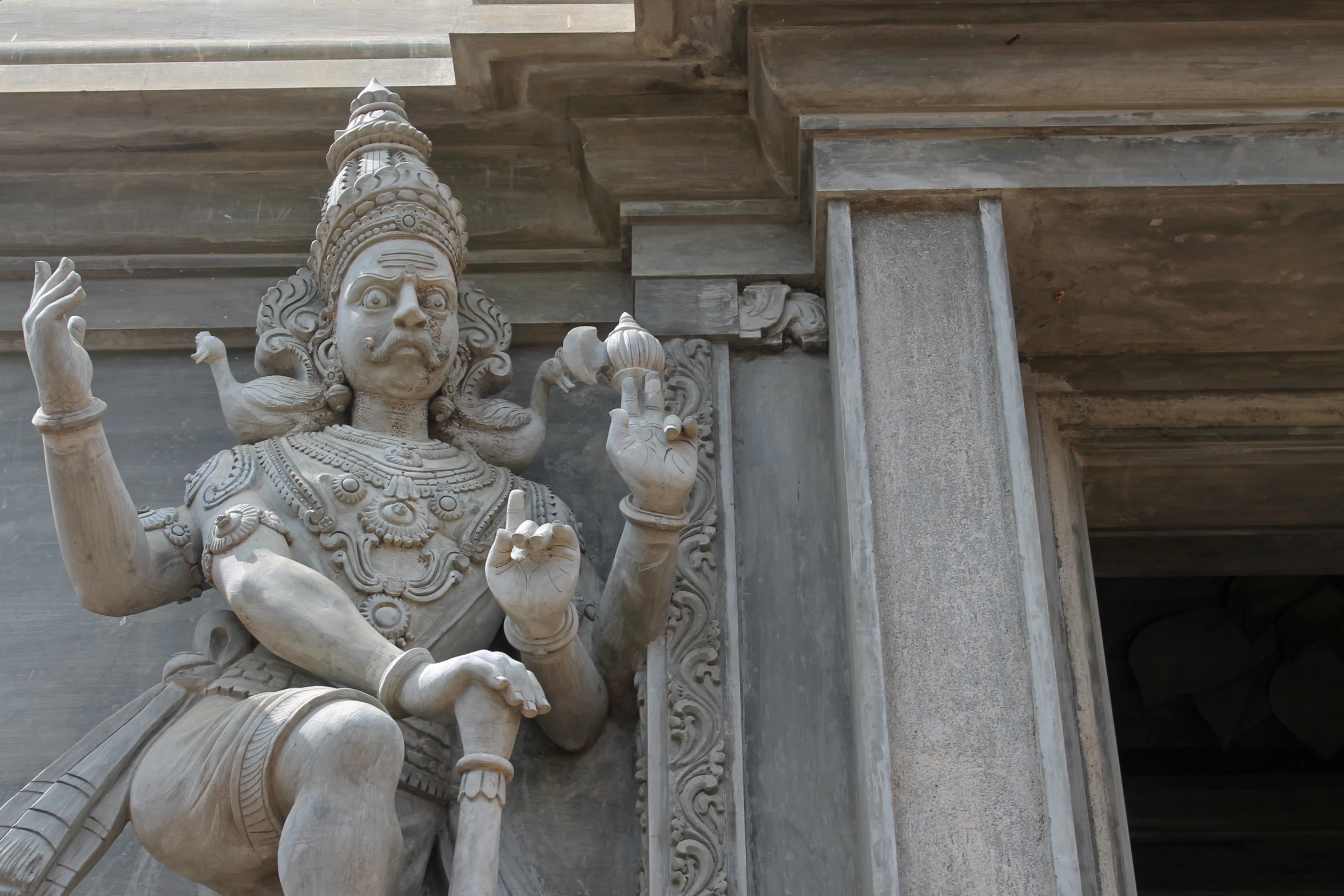 a white statue with his hands in the air