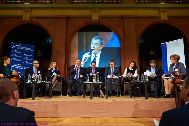 the panelists are sitting on stage at a political meeting