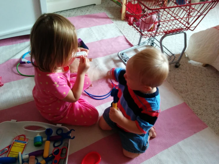 two children on the floor with toys