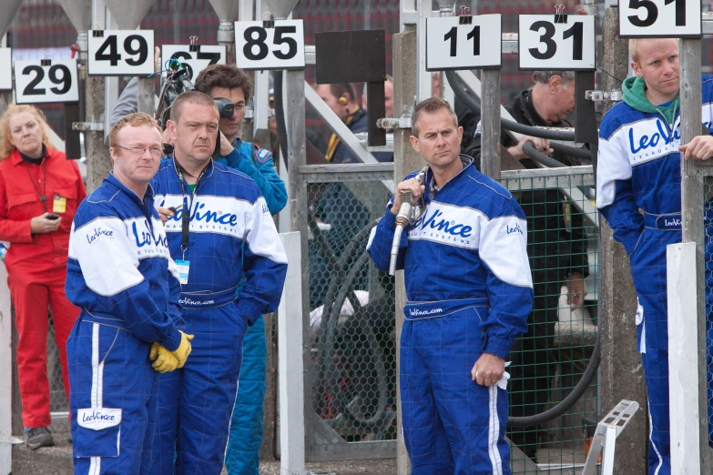 a group of men standing around each other wearing blue and white outfits