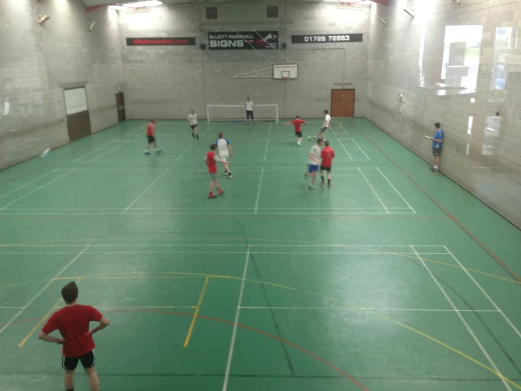 the boys are practicing soccer in an indoor gym