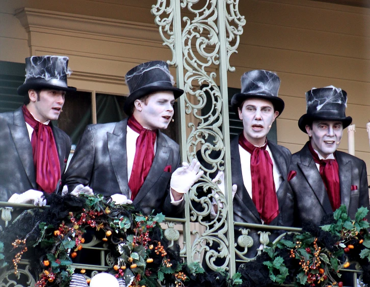 several men in suits and hats stand on a balcony