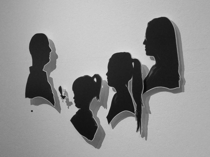 three silhouettes of two women and one girl