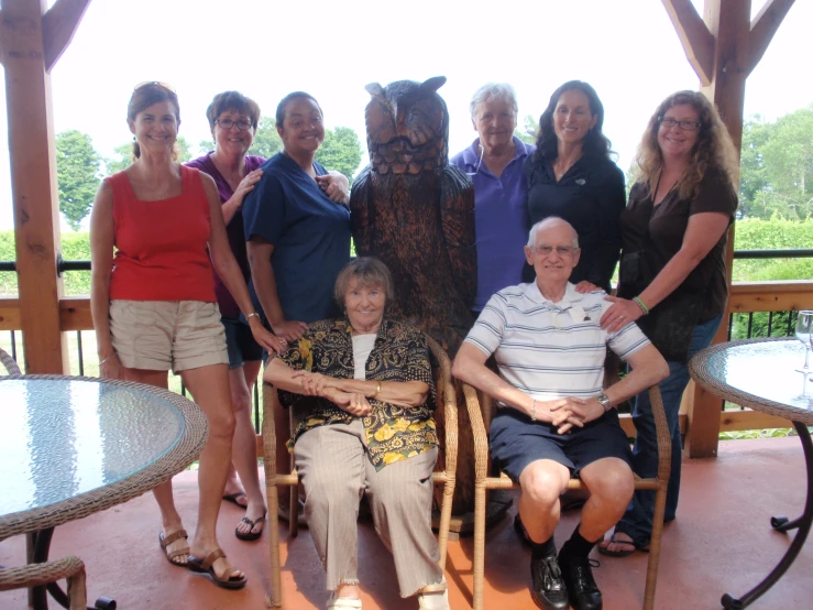 a group of people posing with a statue of a dog