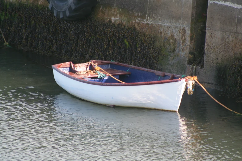 the small boat is tied up to the dock