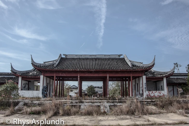 a building with an asian roof next to a field