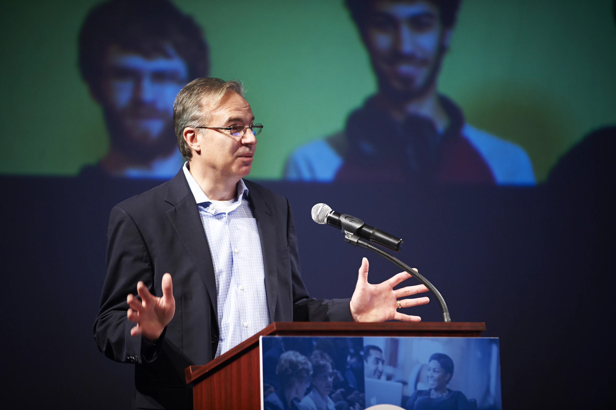 a man giving a speech in front of a stage