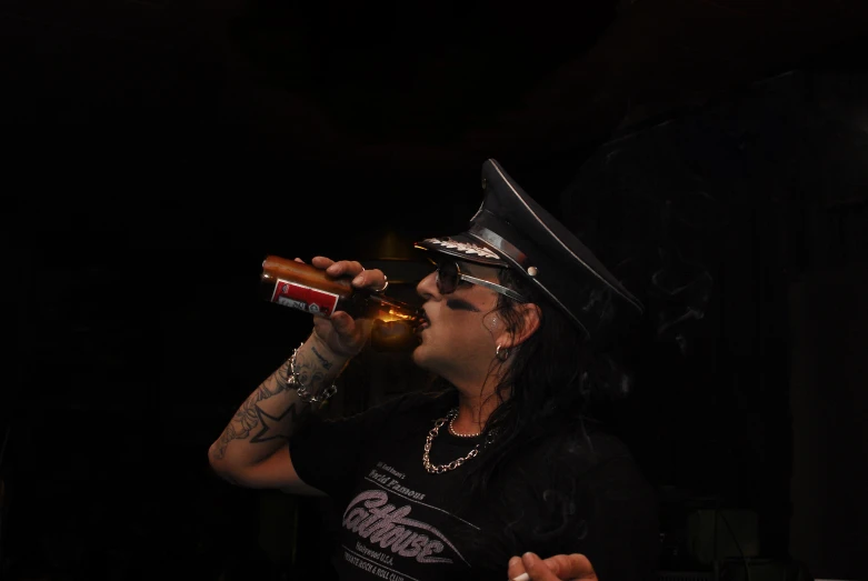 a male singer with an open mouth drinking a beer