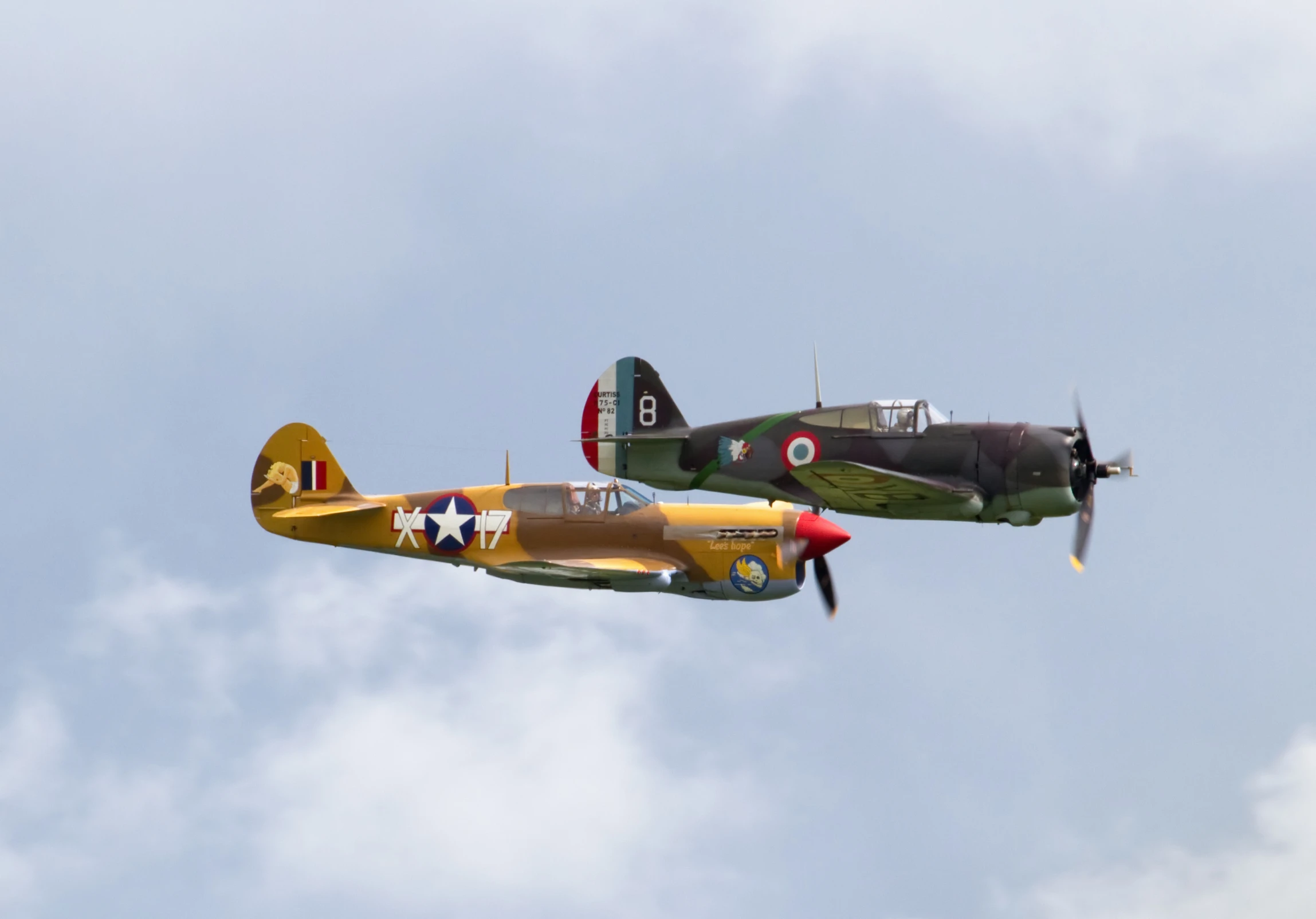 two air planes that are flying through the sky