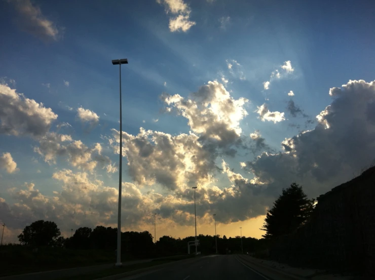 clouds and the sun over a highway on a beautiful day