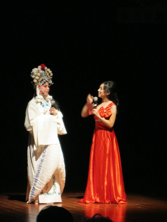 two people with costumes on singing on stage