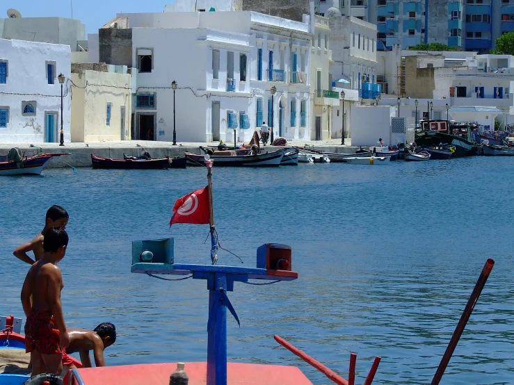 two people sit on the back of a boat in front of a city