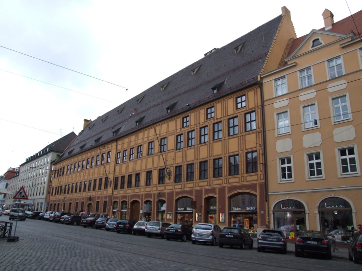 a street with many cars parked outside a very big building