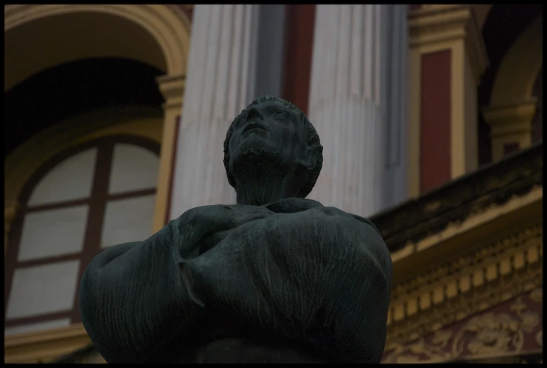 a statue is seen outside a building with columns