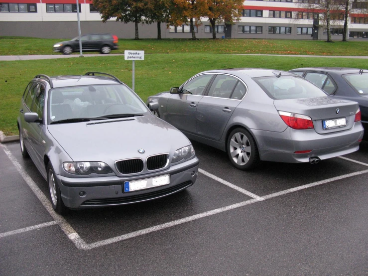 three bmw cars are parked in an empty lot