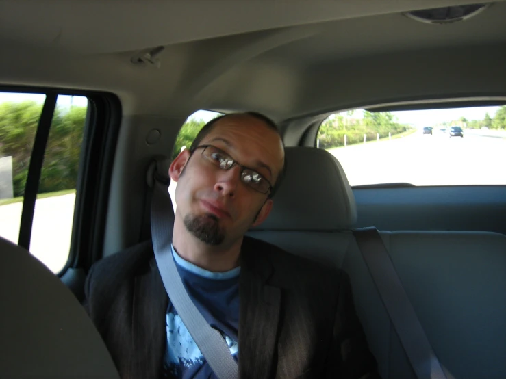 a man is sitting in a car looking to the side