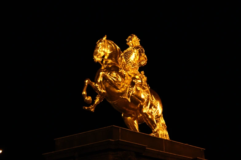 a golden statue is lit in the night sky