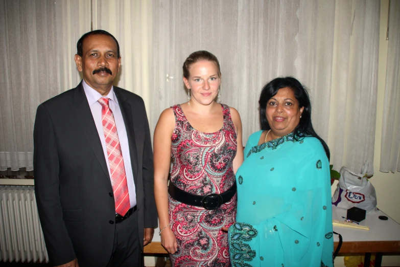 two people and a woman are posing for a po