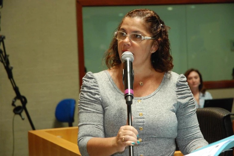 a lady holding up a microphone in an office