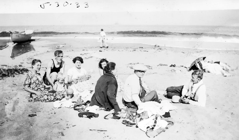 a group of people sitting on a beach near the ocean