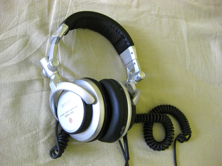 a headphone lying on top of a bed with an audio cord