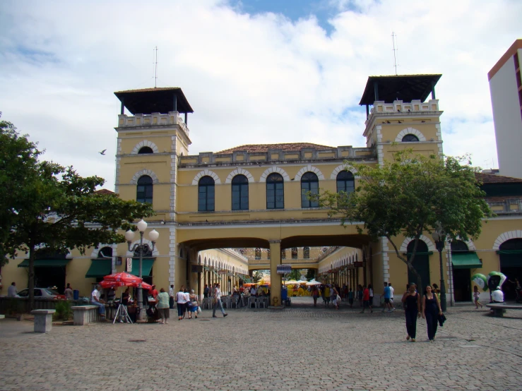 a yellow building with two clocks in front