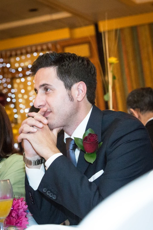 a man in a suit sits next to a woman at a banquet table