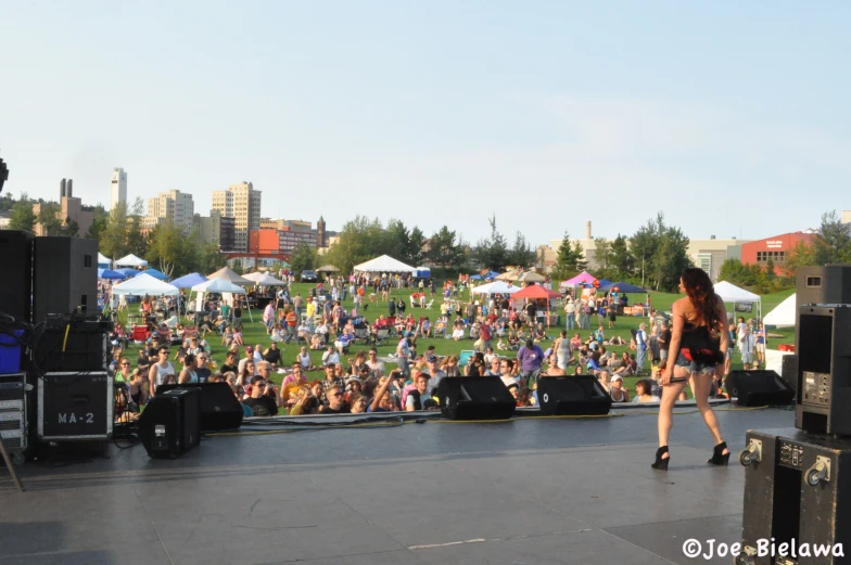 a woman standing on top of a stage with an audience in the background