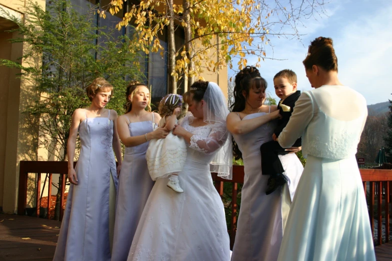 a bride and her bridesmaids outside with a friend