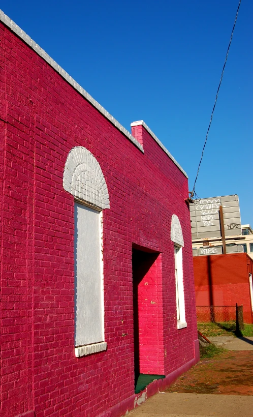 a red building with white windows in the front and a street sign on top