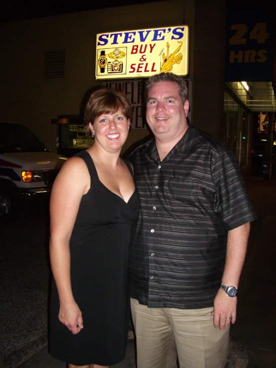 two people standing outside a store front