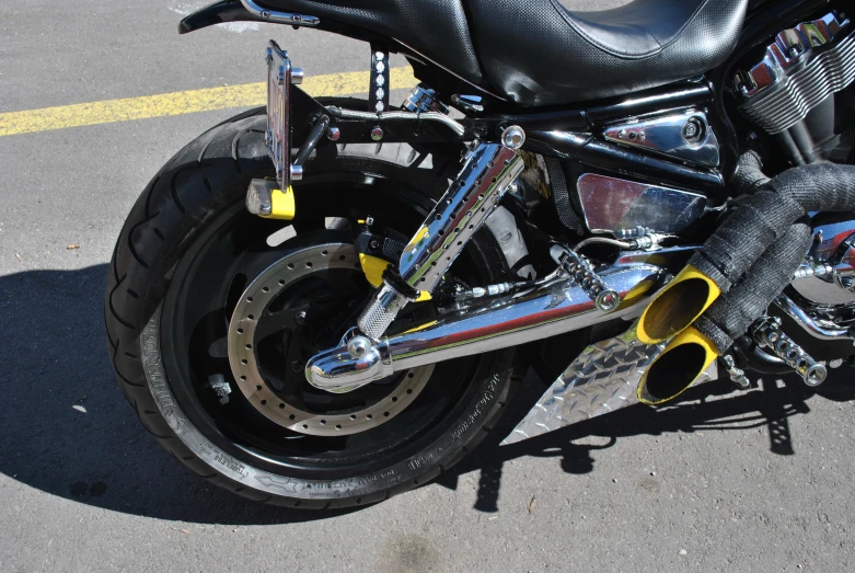 a black and yellow motorcycle is parked on the side of a road