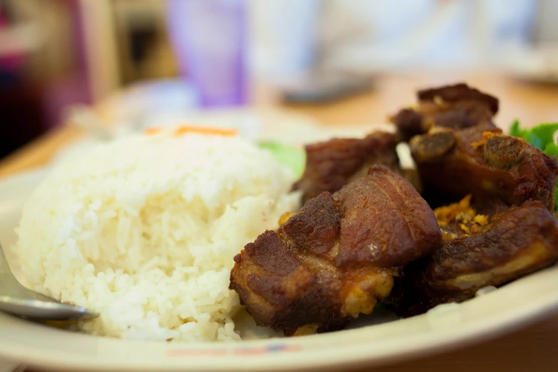 rice and beef on a white plate with fork