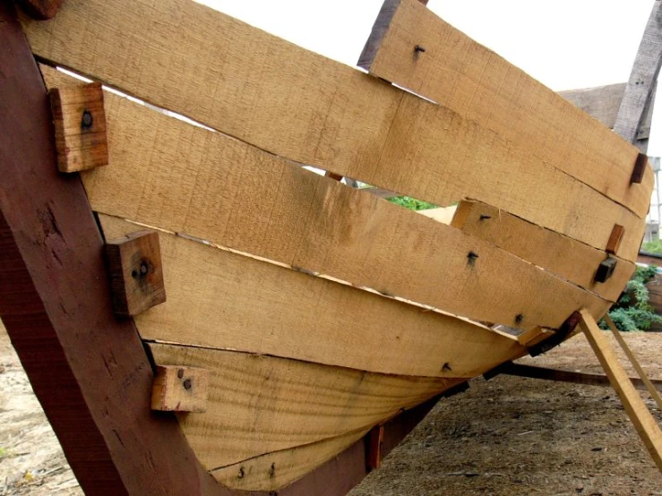 an odd looking boat made out of wood in a yard