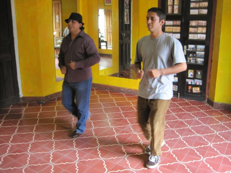 two men in a yellow room playing a video game