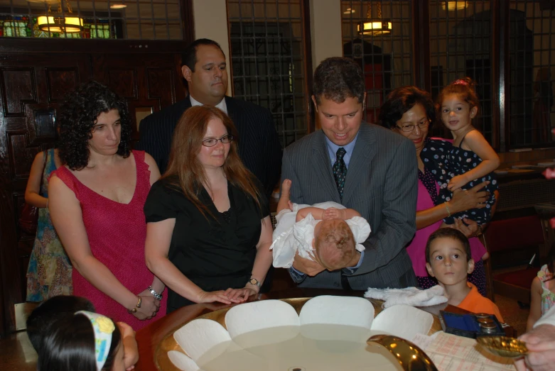 a man holds a baby in front of other people