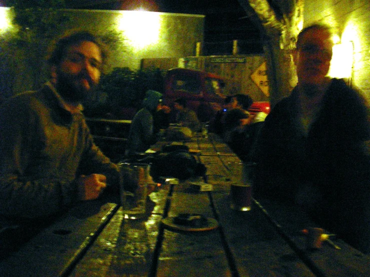 two men are having conversation while sitting at the table