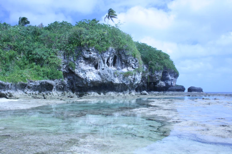 a lagoon near a cliff on the shore of a tropical island