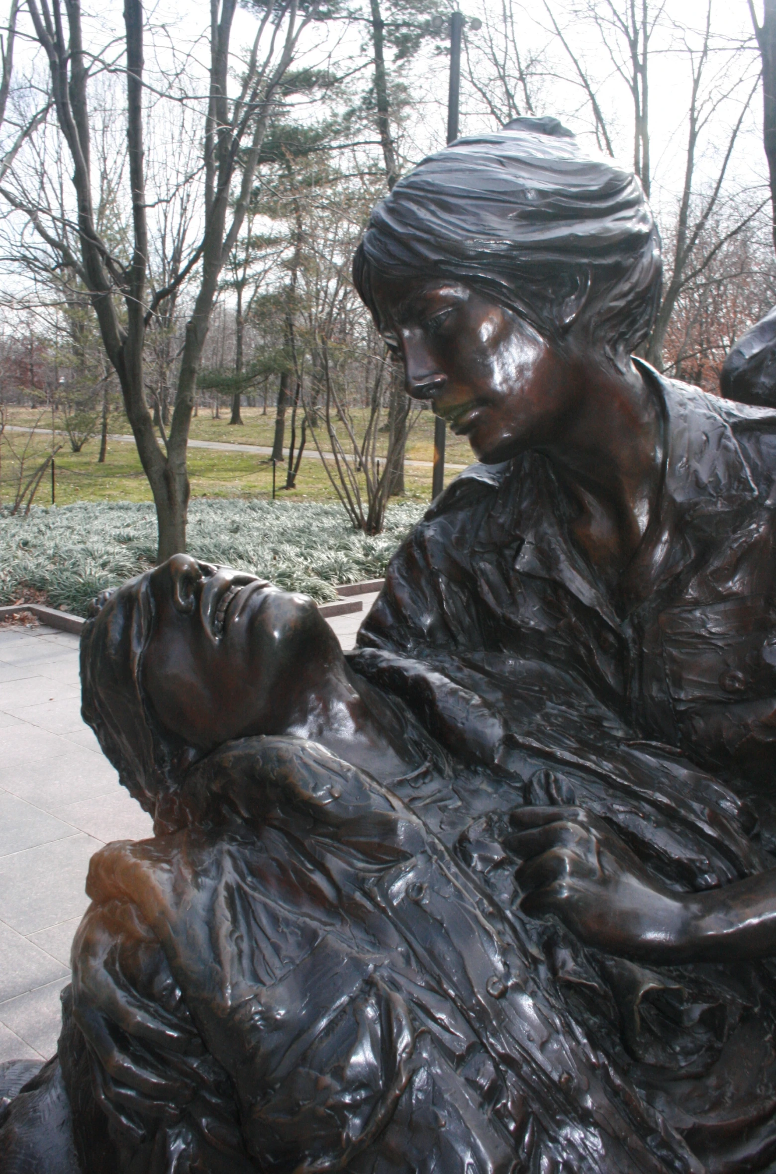 a large sculpture of a woman in an emce next to trees