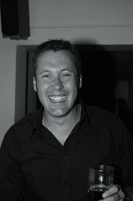 a man standing holding up a glass with a drink