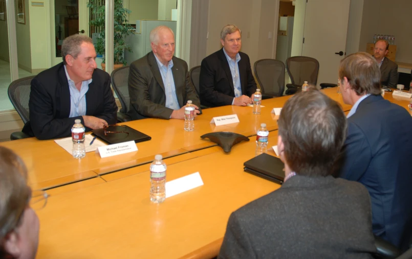 a group of men sitting around a table with water bottles