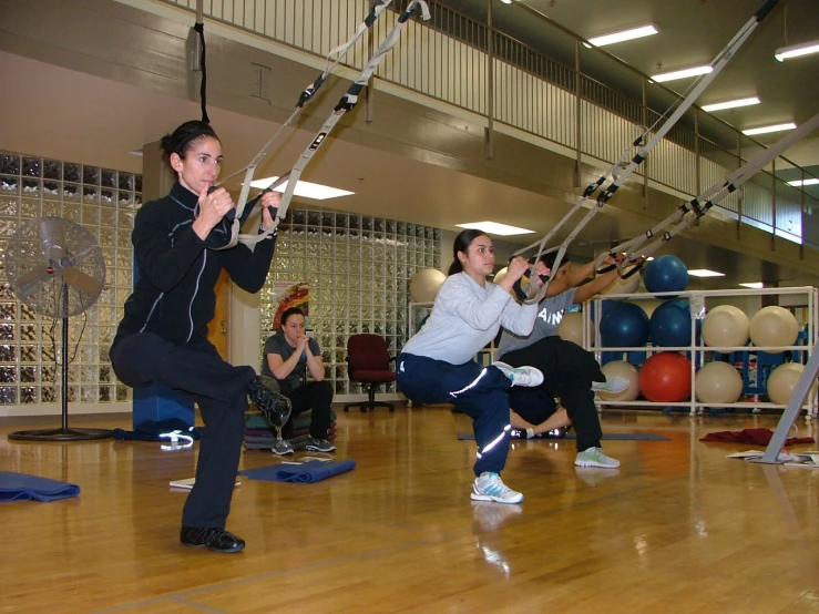 woman on parallel rope exercise swings at a gym